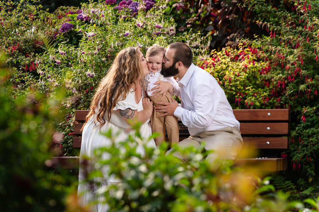 Parents kissing their son's cheeks during golden hour family photos at the Tacoma rose garden