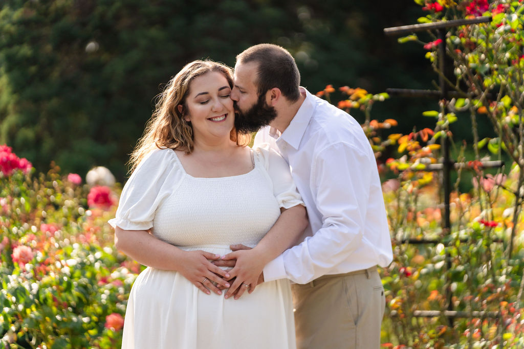 Kiss on the cheek during a golden hour engagement session at the Point Defiance Rose Garden