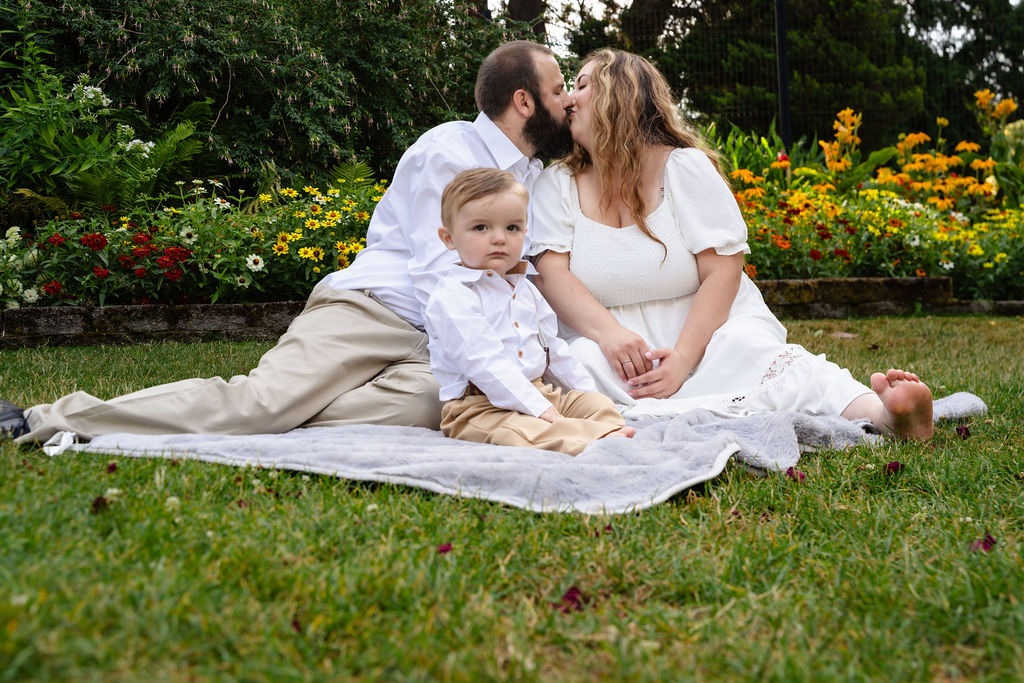 Family of three on a blanket by the flower beds at the Point Defiance Rose Garden in Tacoma