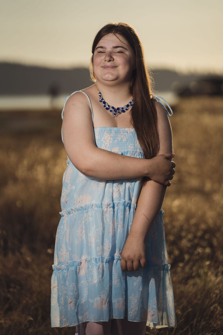 Senior portrait in the golden wheat colored grass at Chambers Bay near Tacoma