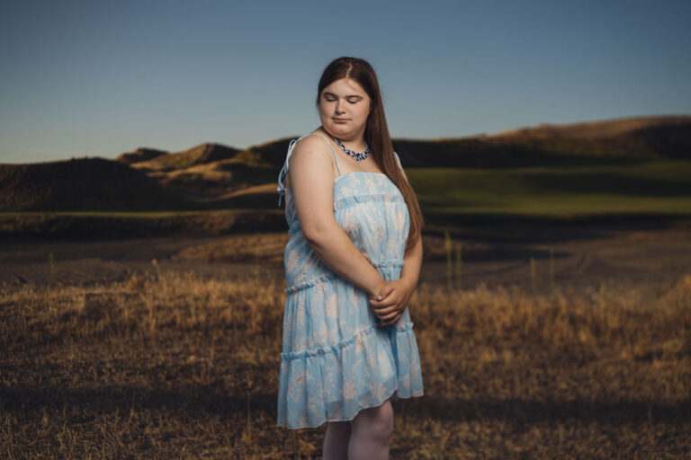 Senior portrait in the wheat colored grass above the links at Chambers Bay