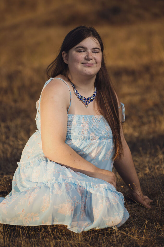 Close senior portrait seated in the warm evening light at Chambers Bay near Tacoma