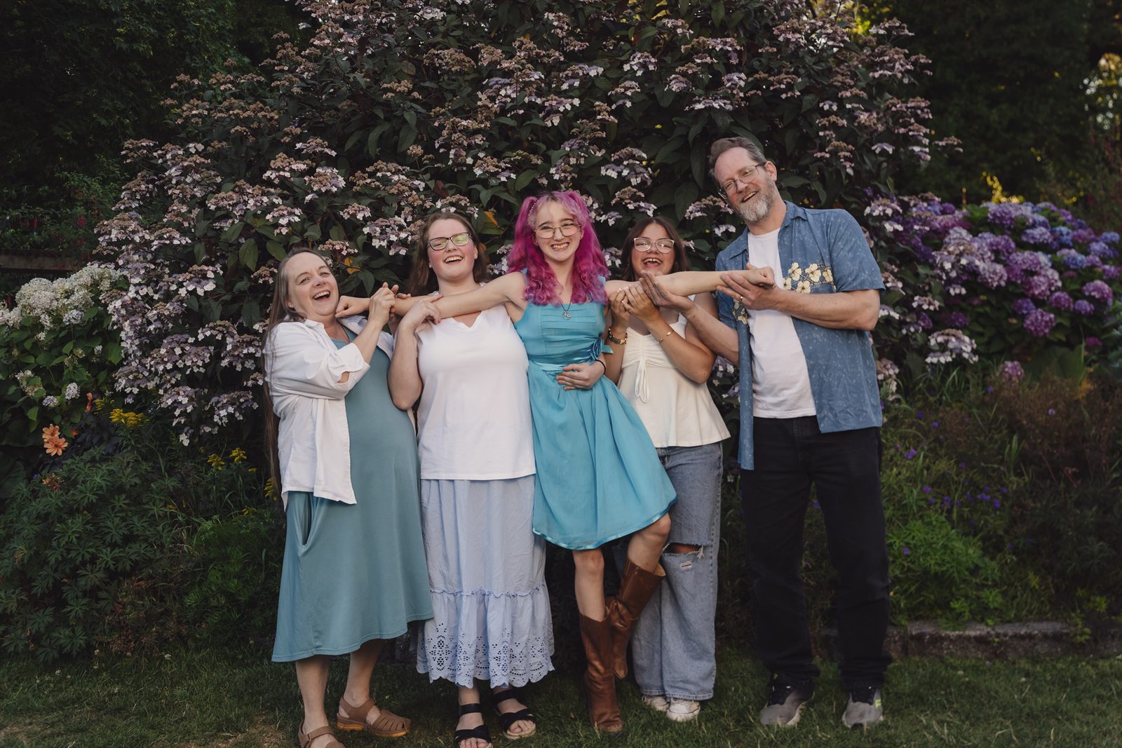 Playful family group in front of a blooming hydrangea wall at Point Defiance Rose Garden in Tacoma