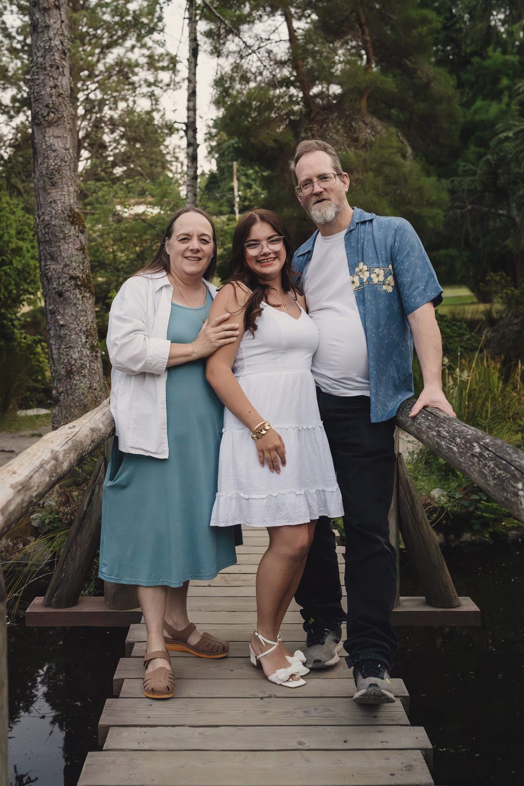 Family standing together on the footbridge over the pond at Point Defiance Park in Tacoma