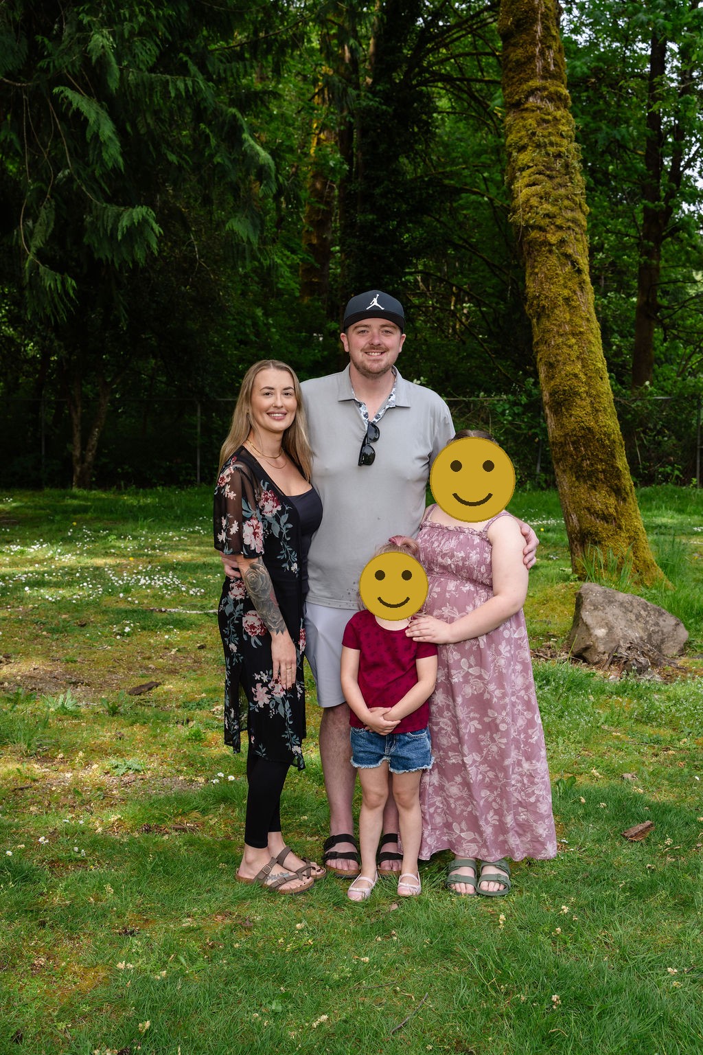 Family of four posing under the trees at a Kitsap County park