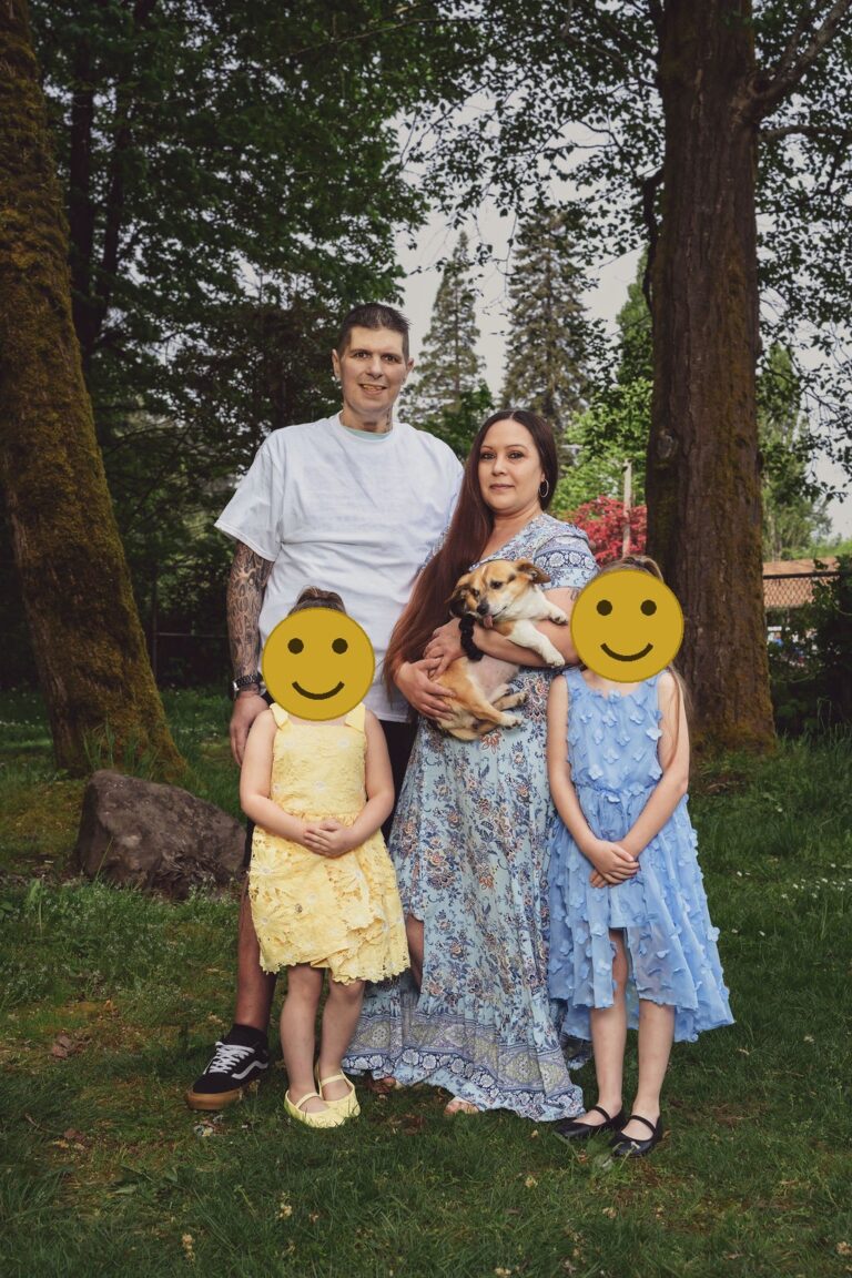 Family of four holding their small dog during a Kitsap County session, faces covered for privacy