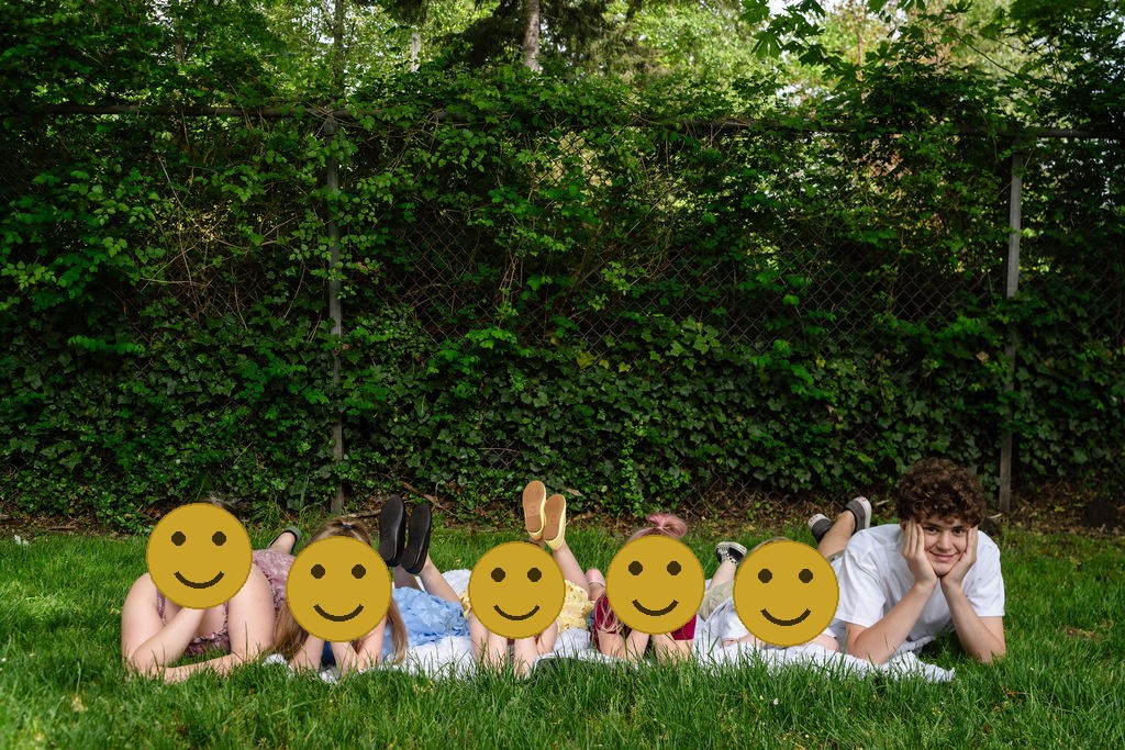 Group of children lying together in the grass during an outdoor family photo session in Washington