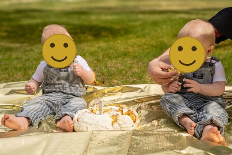 Dad hand feeding cake to his baby during an outdoor first birthday cake smash family session in Kitsap County