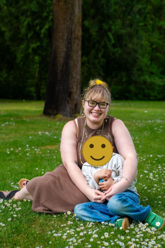 Mother and her son smiling together in a grassy park meadow in Kitsap County