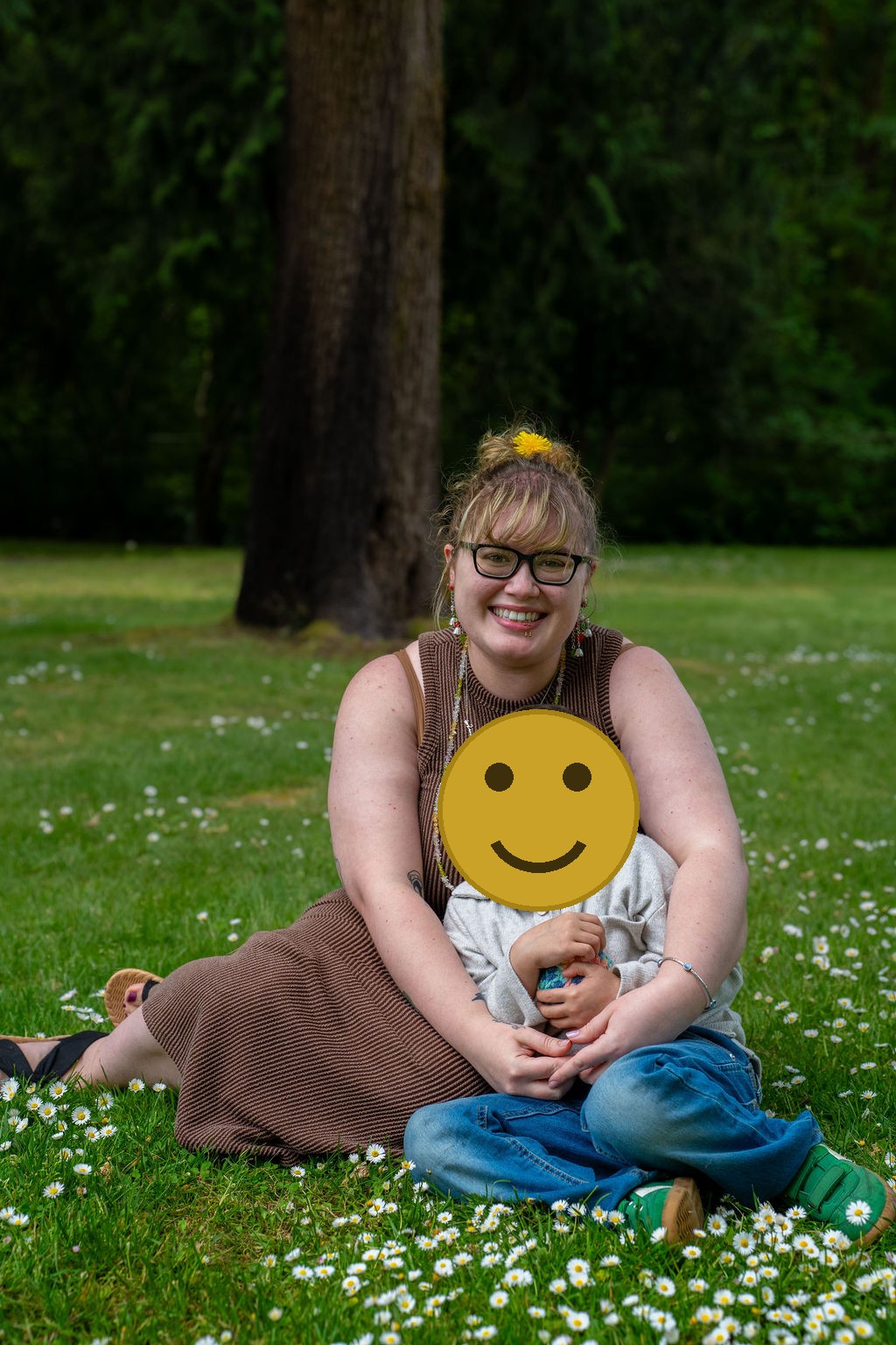 Mother and her young son sitting in a daisy meadow during a Kitsap County family session
