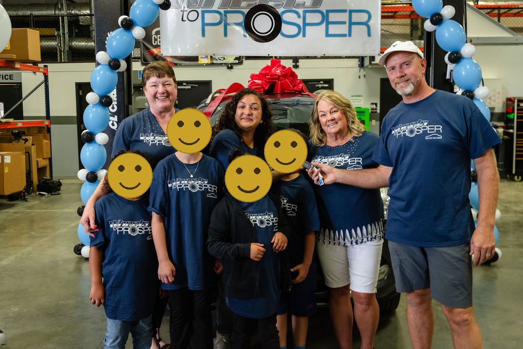 Volunteers handing car keys to a mother and her children in Tacoma, faces covered for privacy