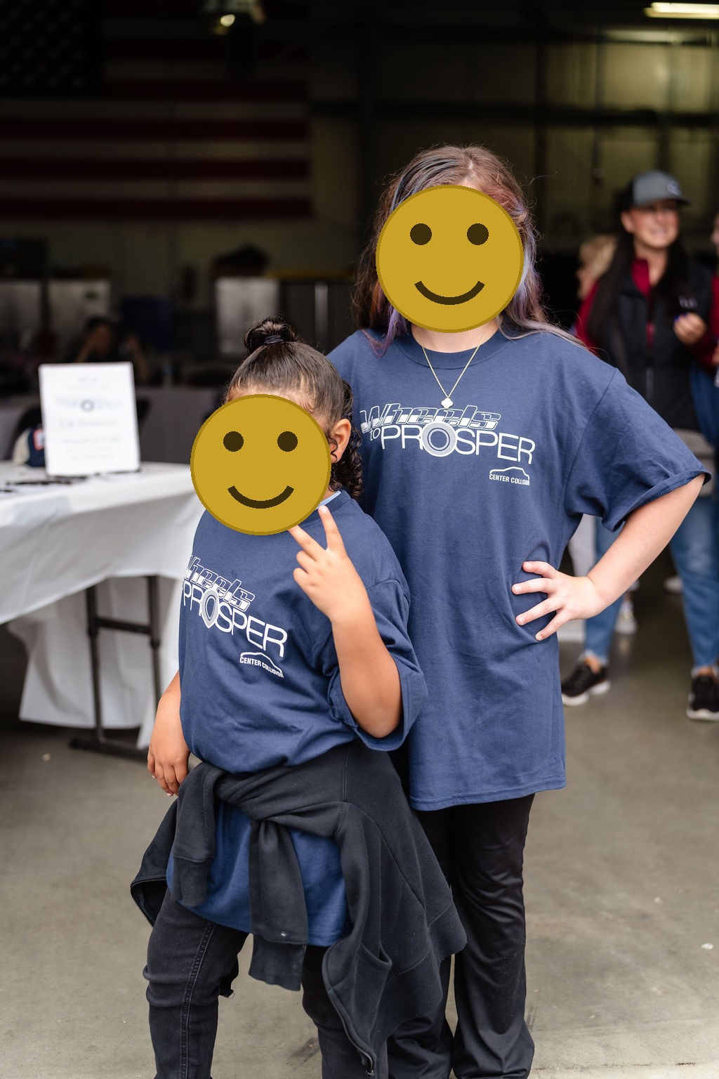 Two girls with painted faces wearing Wheels to Prosper shirts in Tacoma