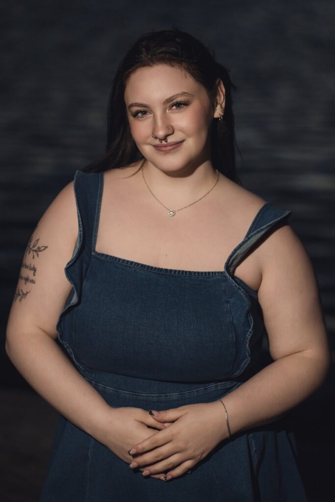 Evening senior portrait in a denim dress beside the water at Chambers Bay