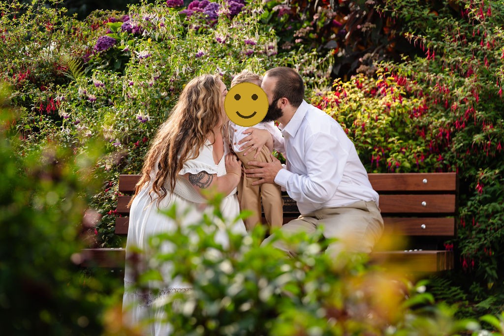 Parents kissing their son's cheeks during golden hour family photos at the Tacoma rose garden