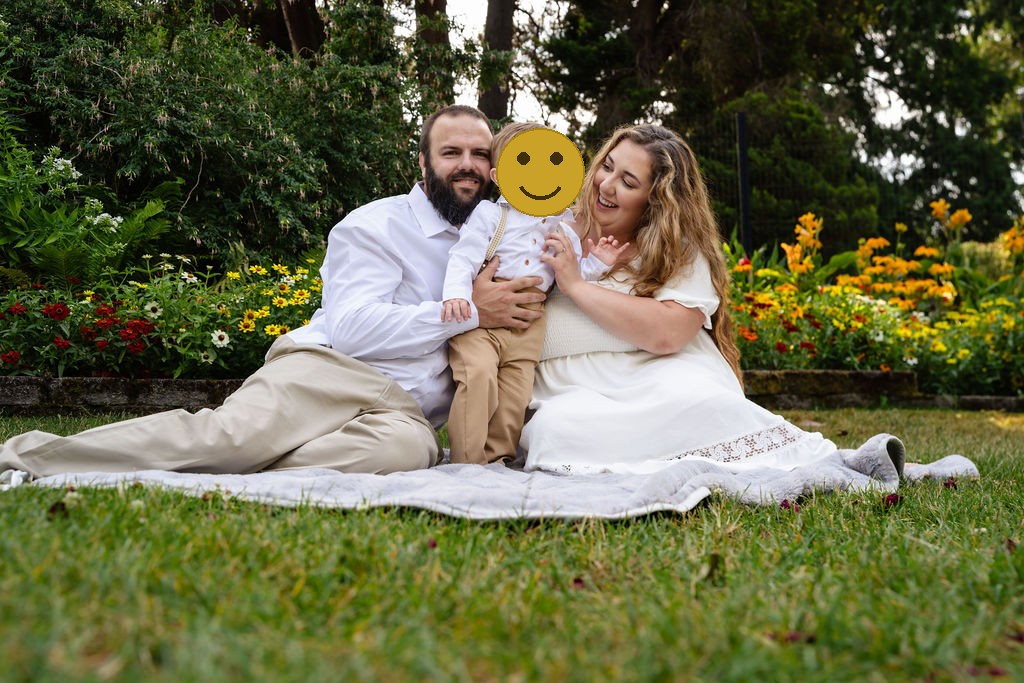 Parents snuggling their little boy on a blanket during golden hour family photos at Point Defiance Tacoma
