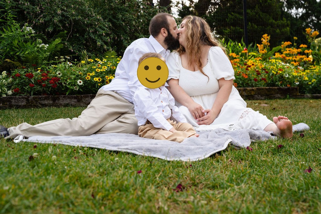 Family of three on a blanket by the flower beds at the Point Defiance Rose Garden in Tacoma
