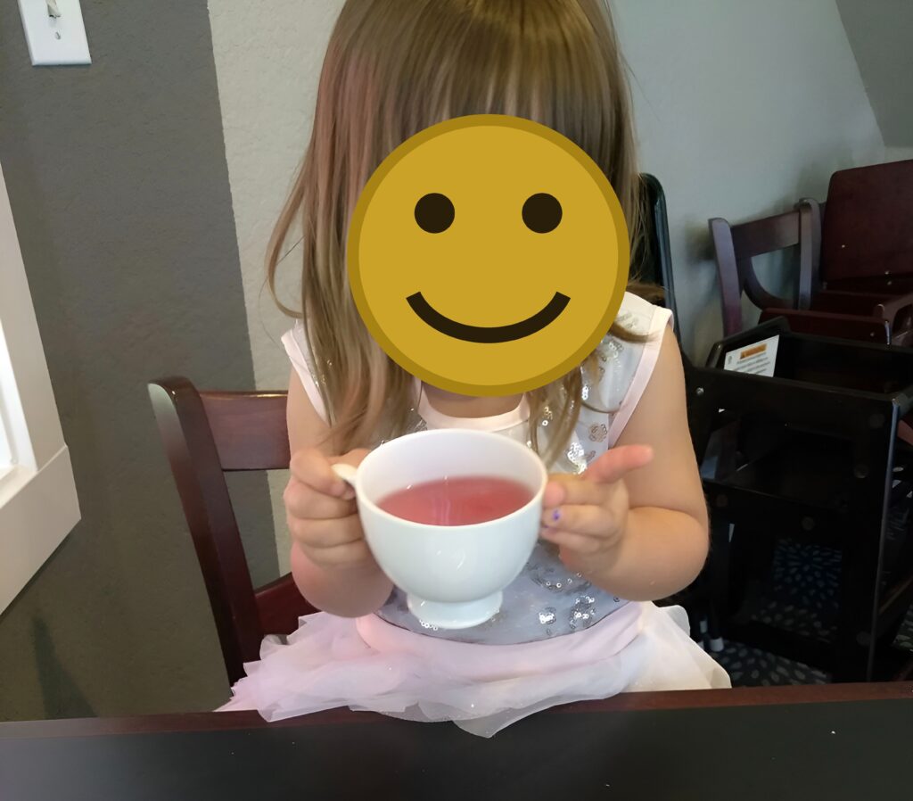 Ava my little girl with a tea cup smiling