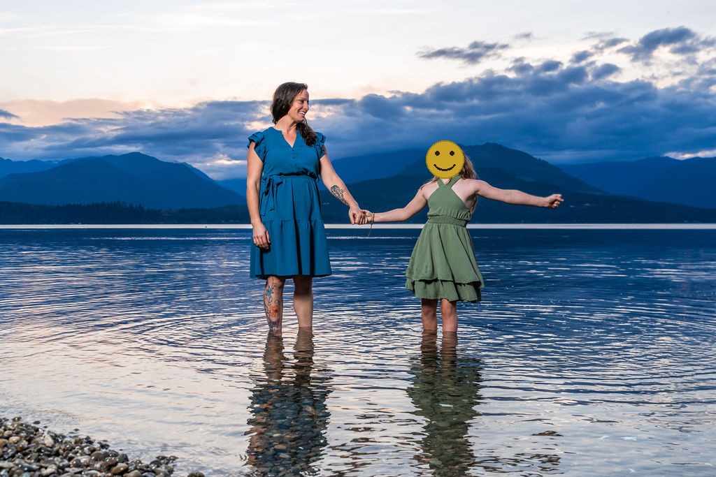 Mother and daughter holding hands in the shallow water at sunset during a family beach session in Washington