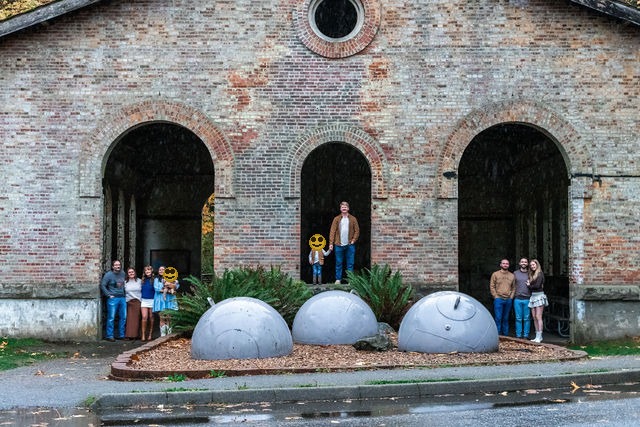 Family at Manchester state park with iconic building, faces covered for privacy