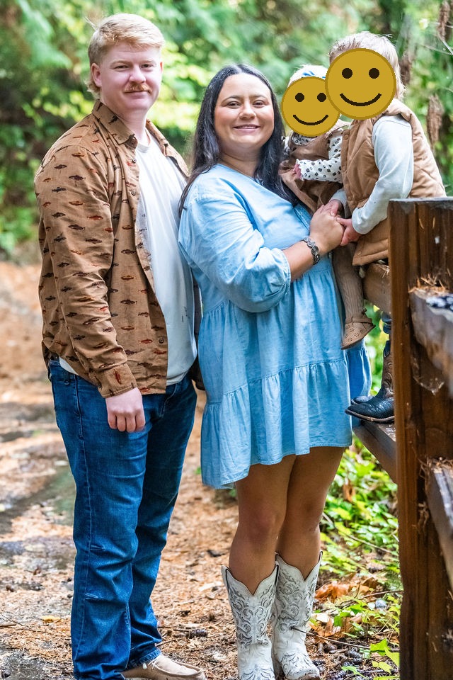 Young family of four posing by a rustic fence during an autumn family photo session in Kitsap County, Washington
