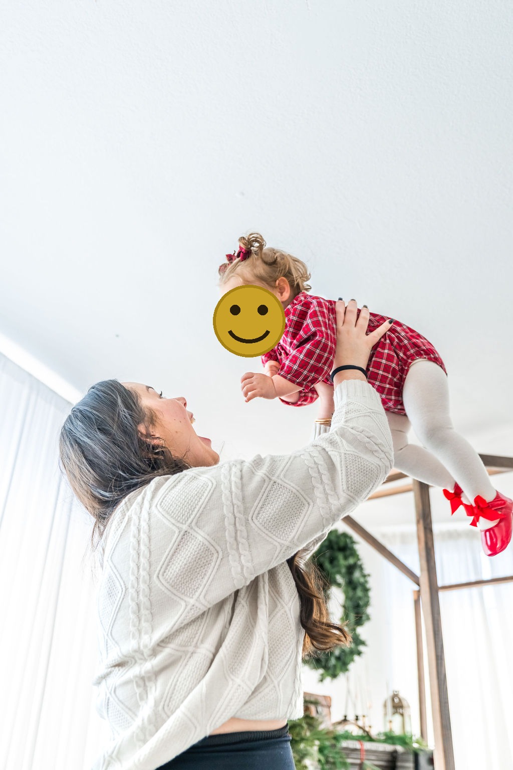 Family photographer capturing a mother lifting her laughing toddler overhead during an indoor family studio session in Washington