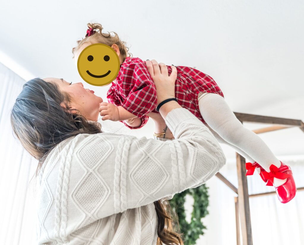 Mother lifting her laughing toddler during an indoor holiday family photo session in Washington