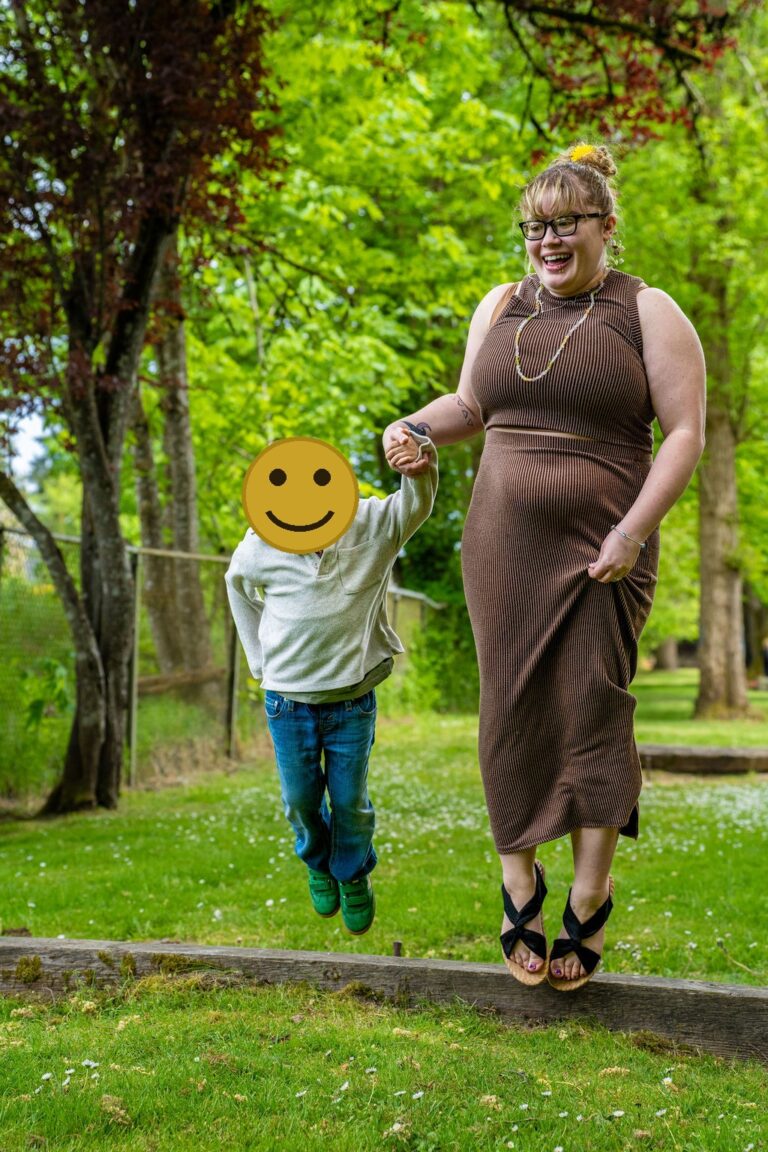 Mother and son laughing while jumping together at a Kitsap County park